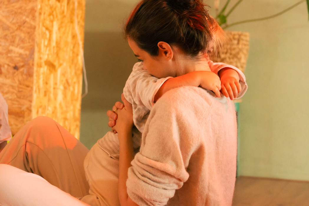 Ouder en kind knuffelen tijdens ouder-kind yoga